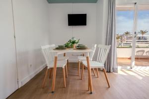 ein weißes Esszimmer mit einem Tisch und Stühlen in der Unterkunft Nura Houses Magaluf Beach - Superior Apt in Magaluf + 35 Fotos