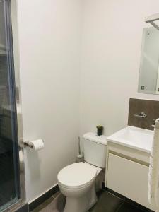 a white bathroom with a toilet and a sink at Reamo Suites in Gaborone +6 photos