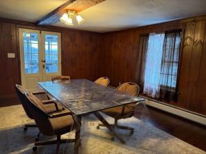 Un comedor con una mesa de cristal y sillas. en Cabin Perfect for Nature Lovers, en Stephentown