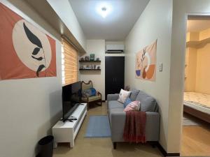 a living room with a couch and a bed at Bless View at 16th in Manila