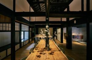 a long wooden table with flowers in a room at RICKA Katsuura in Katsuura