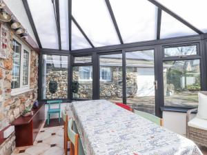 un salón acristalado con mesa y sillas en una habitación con ventanas en Meadowlands, en Newport