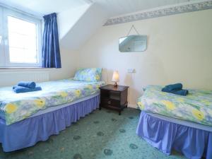 Un dormitorio con dos camas y una mesa con lámpara. en Meadowlands, en Newport