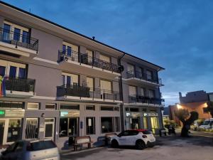 a white car parked in front of a building at ElyCry B&b in Camerano