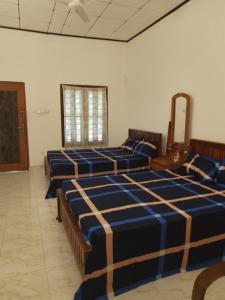 a row of beds in a room with a mirror at Banana Leaf Garden in Weligama
