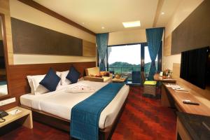 a hotel room with a large bed and a desk at Germanus Springs Kodaikanal in Kodaikānāl