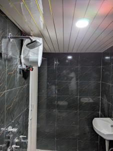 a bathroom with a black tiled wall and a sink at Meenakshi Guest House in Varanasi