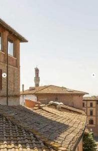 vista su un tetto piastrellato di un edificio di A painting for each window with AIR CONDITIONING! a Siena