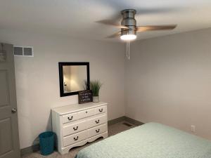 ein Schlafzimmer mit Deckenventilator und Kommode in der Unterkunft Adorable New West 3 BR 2 BA SMRT TV Coffee in Wichita