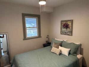 ein Schlafzimmer mit einem grünen Bett und einem Fenster in der Unterkunft Adorable New West 3 BR 2 BA SMRT TV Coffee in Wichita + 14 Fotos