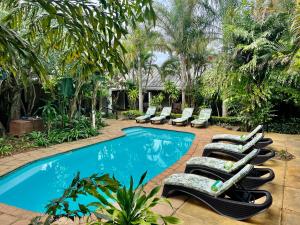 een groep ligstoelen en een zwembad bij Lidiko Lodge in St Lucia