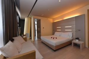 a bedroom with a white bed and a couch at Best Western Plus Net Tower Hotel Padova in Padova