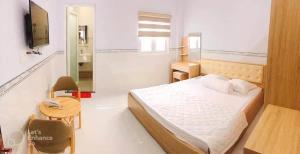 a bedroom with a bed and a table and a mirror at Thuỳ Trang Hotel in Ho Chi Minh City