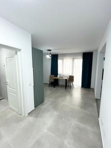 an empty living room with a table and blue curtains at ONE Apartment in Iaşi