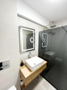 a bathroom with a sink and a shower with a mirror at ONE Apartment in Iaşi