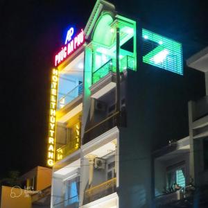 a building with a neon sign on the side of it at Thuỳ Trang Hotel in Ho Chi Minh City