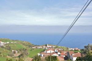 a town on top of a hill next to the ocean at Aldeia do Priolo in Nordeste