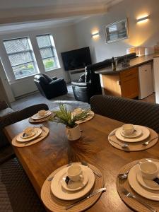 a living room with a wooden table with dishes on it at Sleeps 7, entire apartment,with restaurant next door in Ebchester