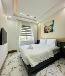 a bedroom with a large bed and a television at Hue An Villa in Bình Tú