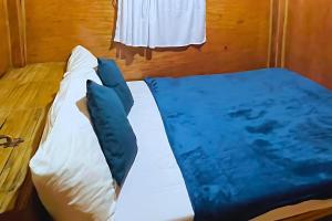 a bed with blue pillows on top of it at Villa Espinoza Beach Resort Nasugbu in Nasugbu