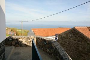 a view of the ocean from the top of a stone wall at Aldeia do Priolo in Nordeste
