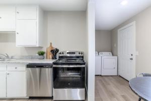 a kitchen with a stove and white cabinets and a table at SUPER CUTE 3 BR 1 BA WIFI Smrt TV 2 Living RM in Wichita
