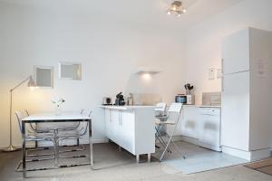 a kitchen with a table and a white refrigerator at Charmant 2 Pièces in Honfleur