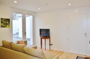 a living room with a couch and a tv at Aldeia do Priolo in Nordeste