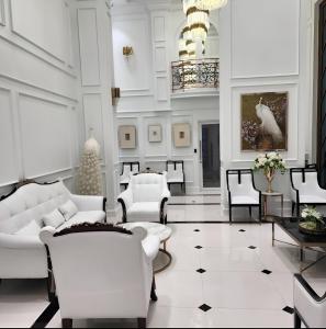 ein Wohnzimmer mit weißen Möbeln und einem Kronleuchter in der Unterkunft The Empire Tower Pattaya in Jomtien Beach