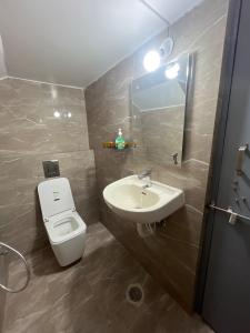 un bagno con un water bianco e un lavandino di Kuteeram - Create Memories a Secunderābād
