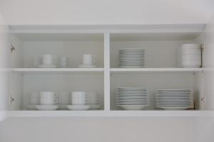 a white cabinet filled with dishes and plates at Aldeia do Priolo in Nordeste