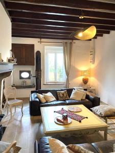 ein Wohnzimmer mit Sofa und Tisch in der Unterkunft Une histoire de famille in Écordal