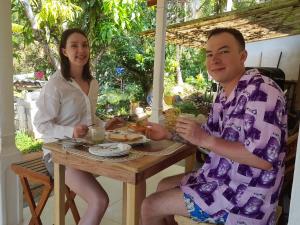 un uomo e una donna seduti a un tavolo di TaMaRiNd house a Hikkaduwa