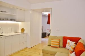 a living room with a couch and a kitchen at Aldeia do Priolo in Nordeste