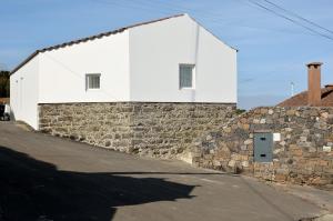 a white building on top of a stone wall at Aldeia do Priolo in Nordeste