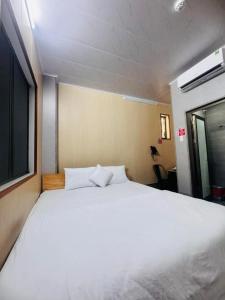 a large white bed in a room with a window at Khách sạn Vinh Hotel in Thốt Nốt