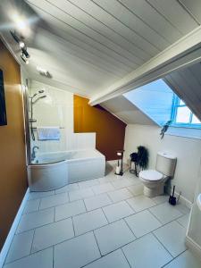 a large bathroom with a tub and a toilet at The Georgian Manor House in Whitehaven