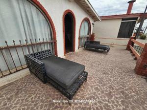 a patio with two black benches on a house at Casa Rustica-secure parking included in Tijuana