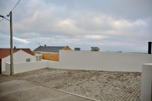 a white fence in front of a house at Aldeia do Priolo in Nordeste