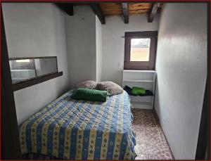 a small bedroom with a bed and a window at Casa Rustica-secure parking included in Tijuana