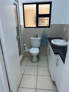a bathroom with a toilet and a sink and a window at Sea- Esta in Densainagar
