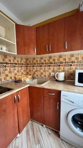 a kitchen with a sink and a washing machine at Saules 73 in Daugavpils +2 photos