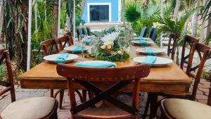 a wooden table with blue napkins and chairs around it at Hostal y Camping Villa Mercedes in Tizimín