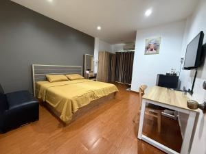 碧差汶Rabbit Hotel的一间卧室，配有一张床、一张书桌和一台电视