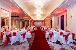 a banquet hall with white tables and red bows at Tower Club at lebua in Bangkok +202 photos