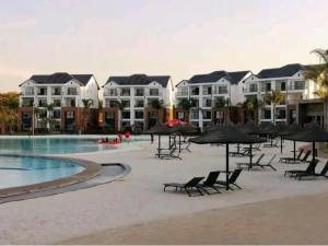 a resort with a pool and chairs and umbrellas at The Blyde SUPER STAR in Pretoria