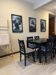 ein Esszimmer mit einem schwarzen Tisch und Stühlen in der Unterkunft Unit One by Hideout Lounge in Kandy