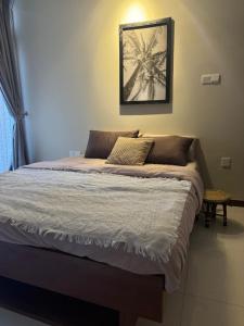ein Bett in einem Schlafzimmer mit einem Bild an der Wand in der Unterkunft Unit One by Hideout Lounge in Kandy