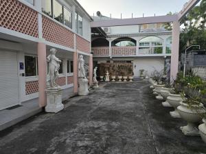a courtyard of a building with statues of people at Jacaranda in Saint-Louis +2 photos