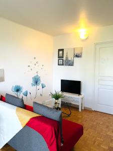 a living room with a couch and a tv at Rosny Sous Bois très charmant l'appartement en plein centre ville et verdure in Rosny-sous-Bois +109 photos